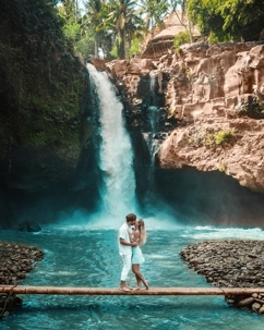 couple kissing in front of a waterfall